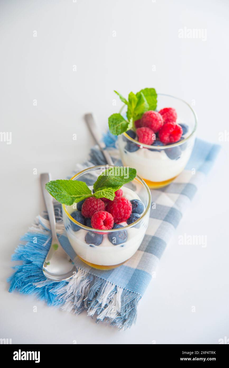 La crema con il miele, mirtilli e lamponi e foglie di menta. Foto Stock