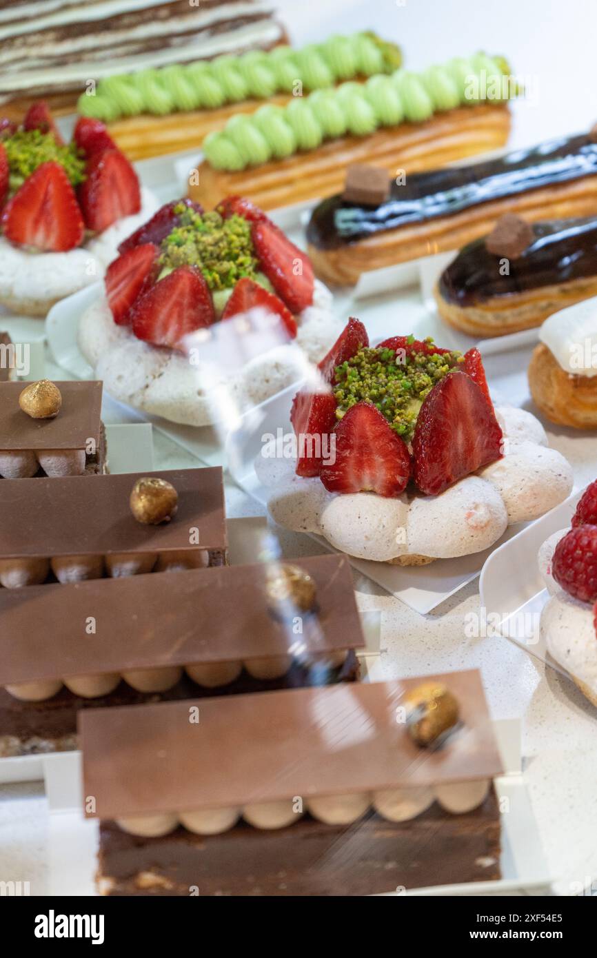 Vari dolci e dolci esposti sugli scaffali in una panetteria francese Foto Stock