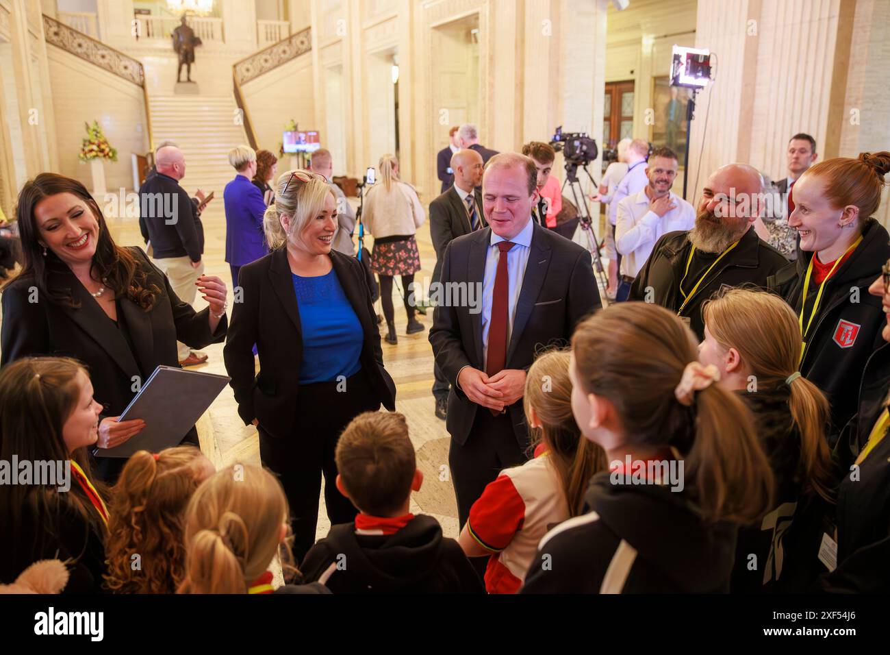 (Da sinistra a destra) il vice primo ministro Emma Little-Pengelly, il primo ministro Michelle o'Neill, il ministro delle comunità Gordon Lyons e il Larne Swimming Club allenano Peter Hill e Danielle Hill, mentre incontrano i membri del Larne Swimming Club durante una visita agli edifici del Parlamento a Stormont. Data foto: Lunedì 1 luglio 2024. Foto Stock