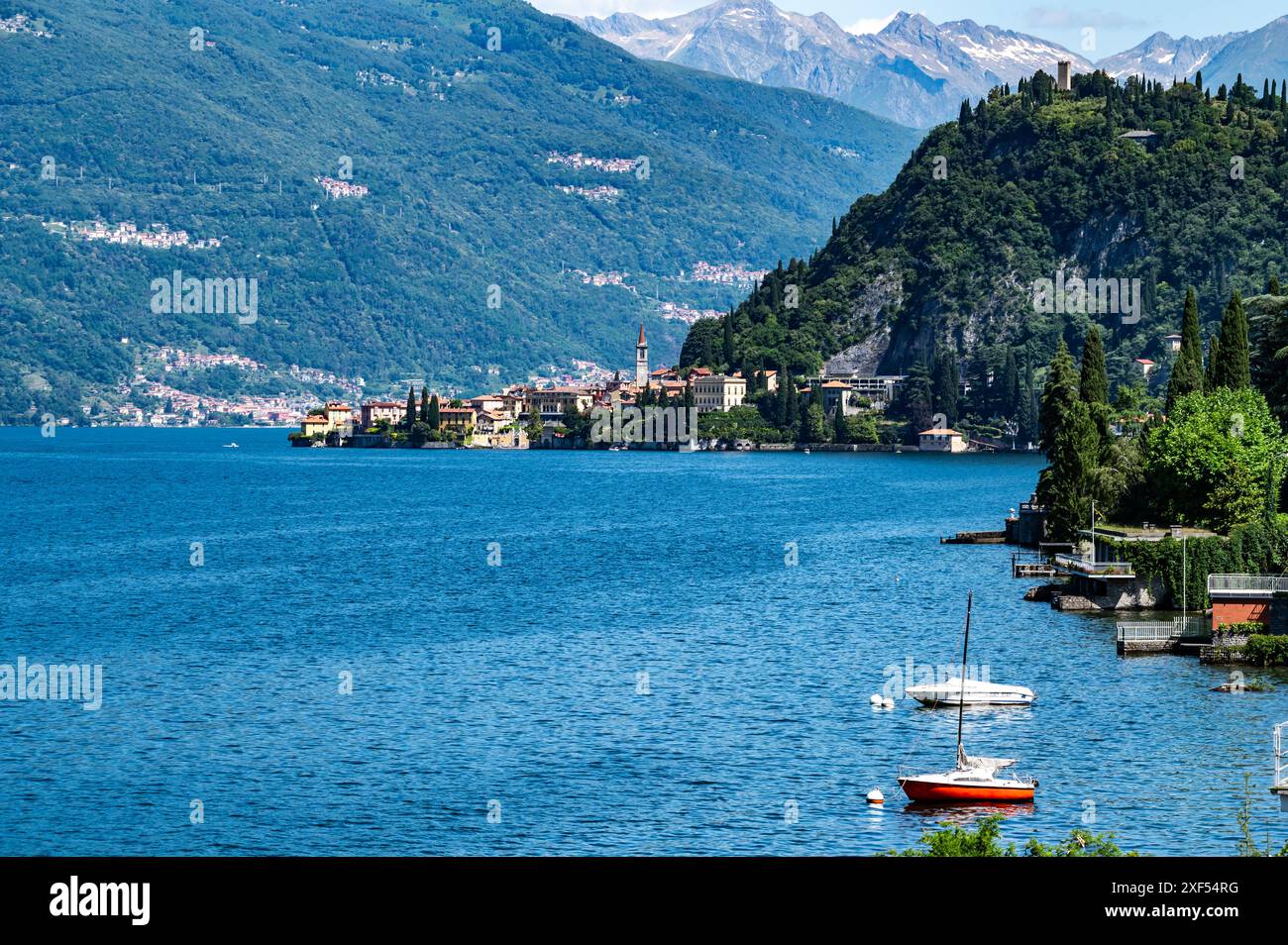 La città di Varenna, sul lago di Como, fotografata da lontano, e il castello di Vezio. Foto Stock