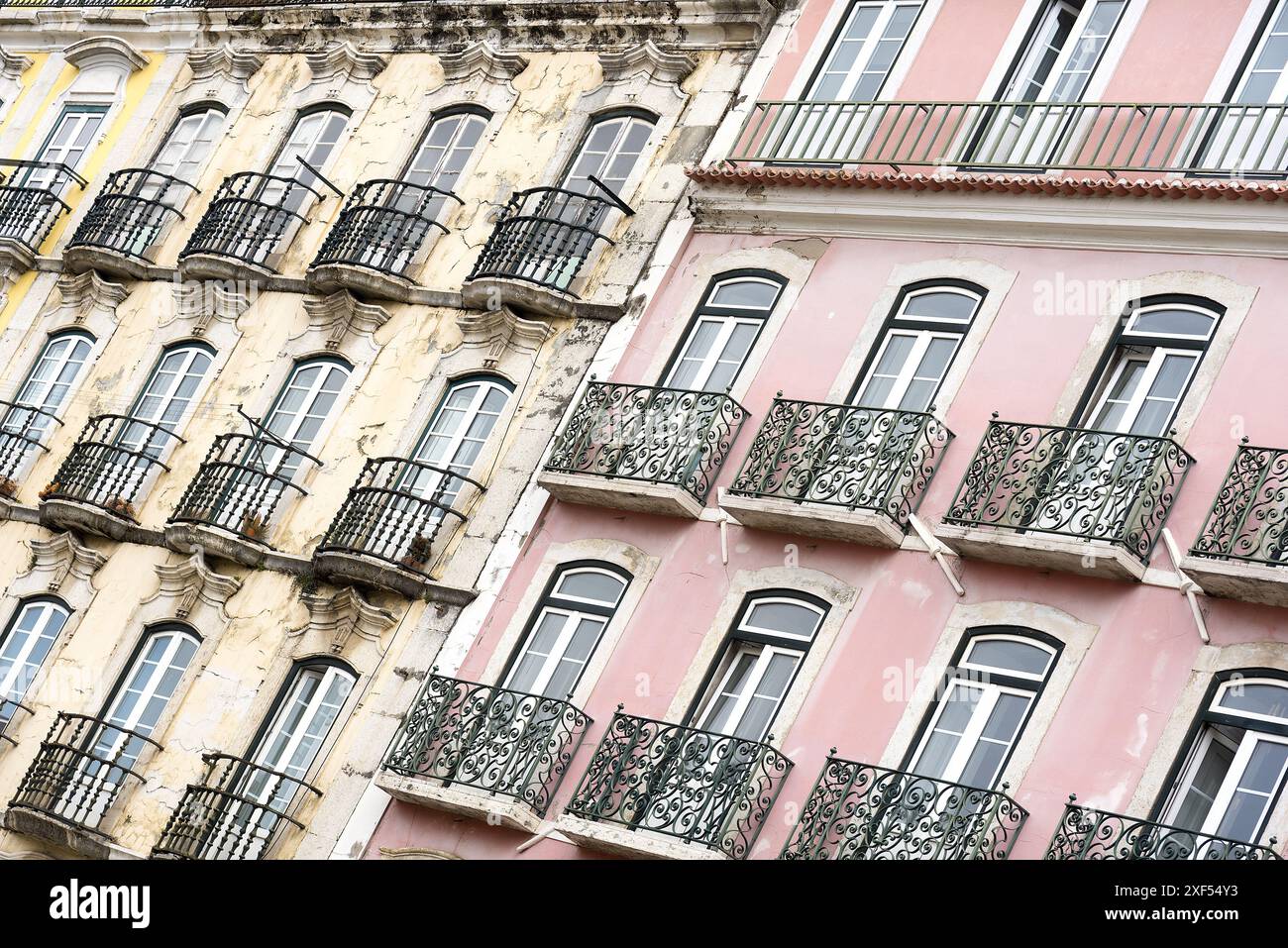 Lisbona Portogallo: Tipica facciata di un edificio tradizionale con finestre strette e balconi in ferro battuto posti ad angolo. Foto Stock