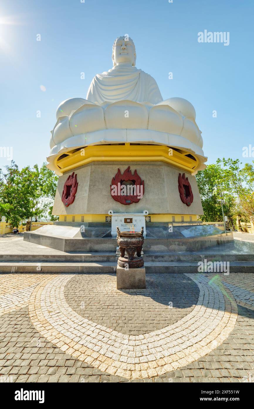 Vista dal basso della gigantesca statua bianca del Buddha sullo sfondo blu del cielo presso la Pagoda di hai Duc a Nha Trang, provincia di Khanh Hoa in Vietnam. Foto Stock