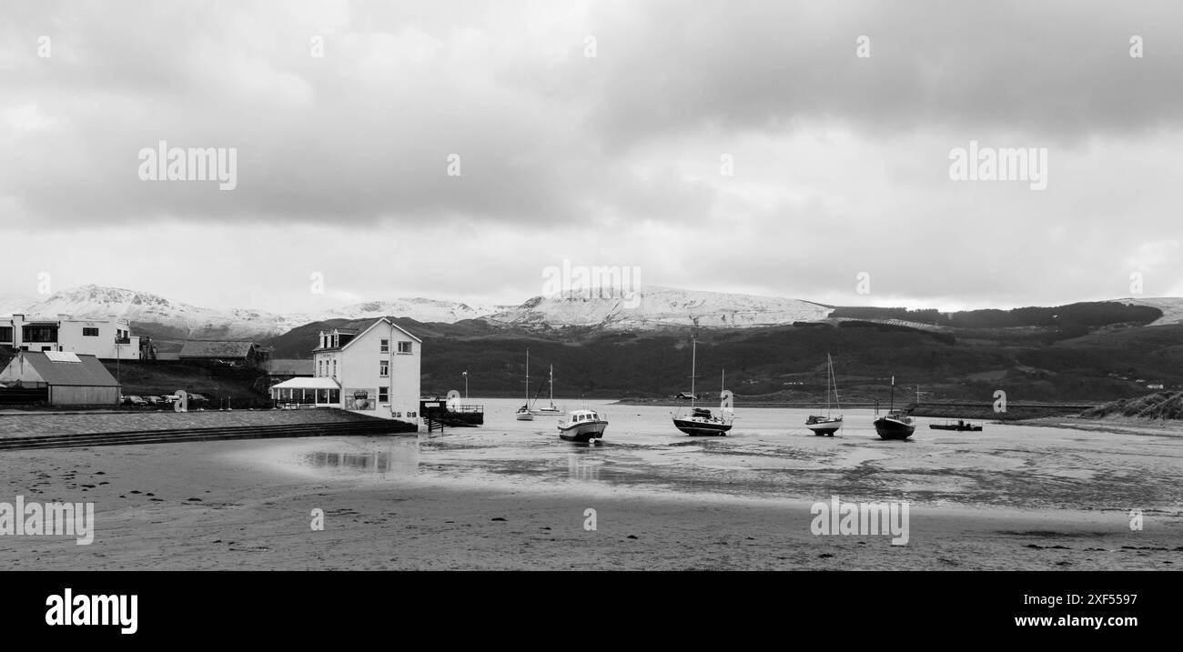 Porto di Barmouth con la sponda sud-occidentale innevata del Parco Nazionale di Eryri (Snowdonia) sullo sfondo, Galles del Nord Regno Unito. Marzo 2024. Foto Stock