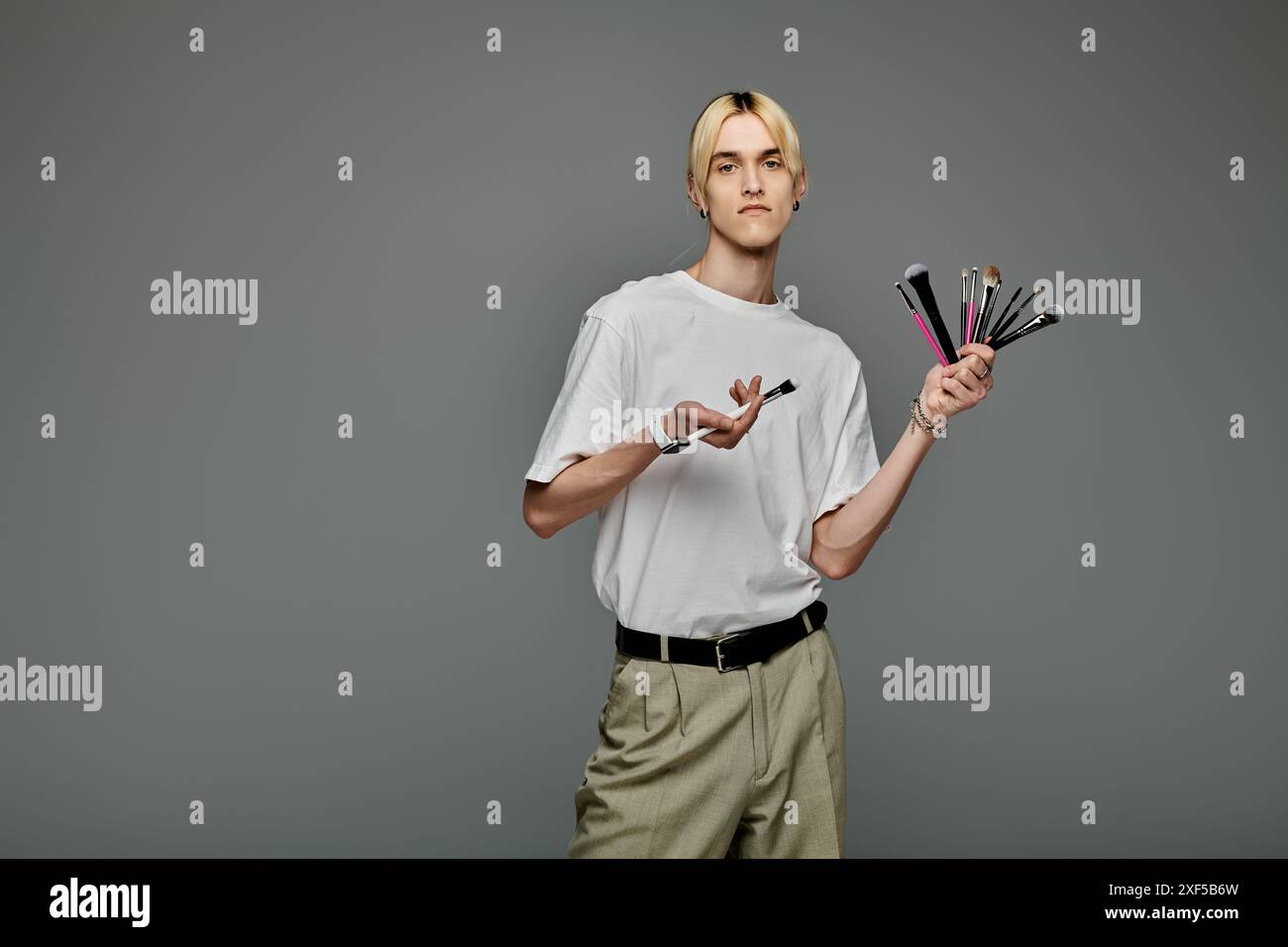 Un uomo con un mucchio di pennelli in mano. Foto Stock
