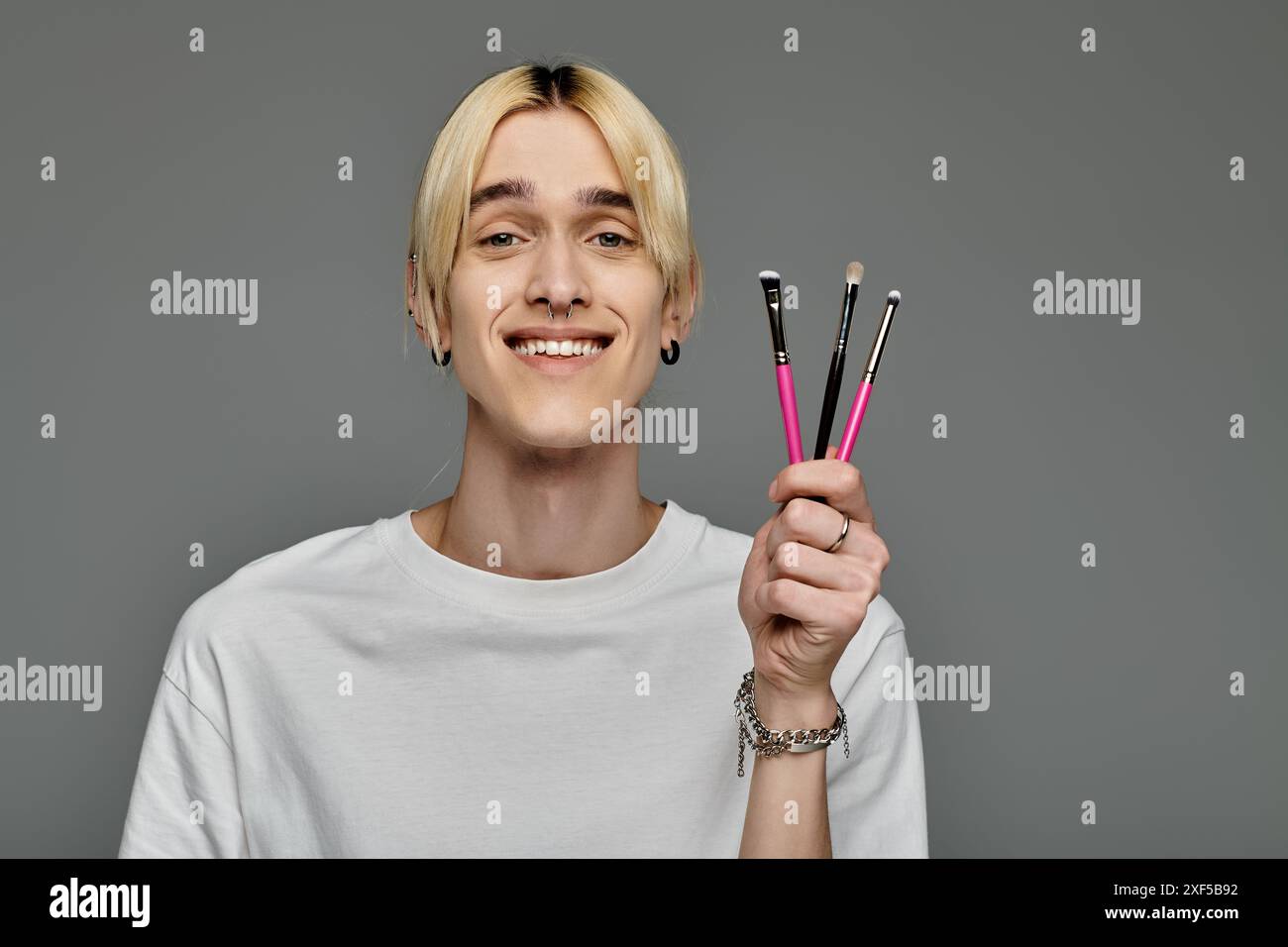 L'uomo tiene in mano con sicurezza tre pennelli. Foto Stock