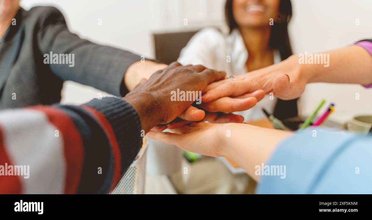 Un gruppo di persone si tiene per mano in cerchio. Le persone sono di razze e generi diversi. La scena è una di unità e di Unione Foto Stock
