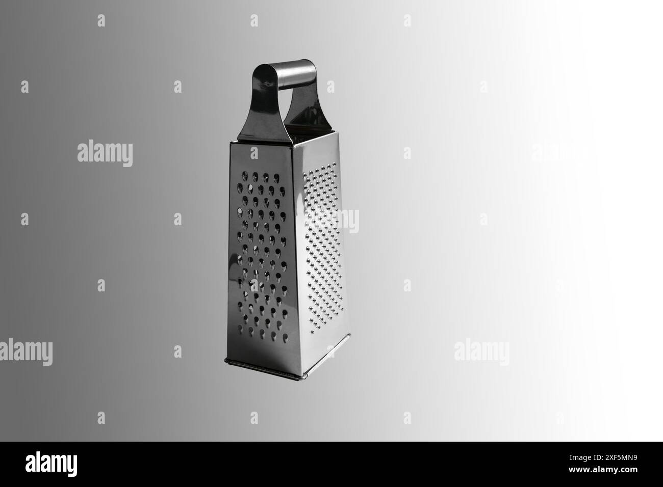 Grattugia verdure manuale. Primo piano. Isolato su sfondo grigio. Foto Stock