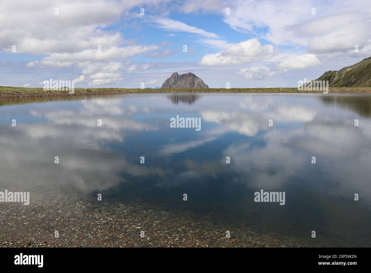 Vista di una riserva di montagna, le cui acque blu riflettono nuvole bianche, la Wildkogel-Arena Foto Stock
