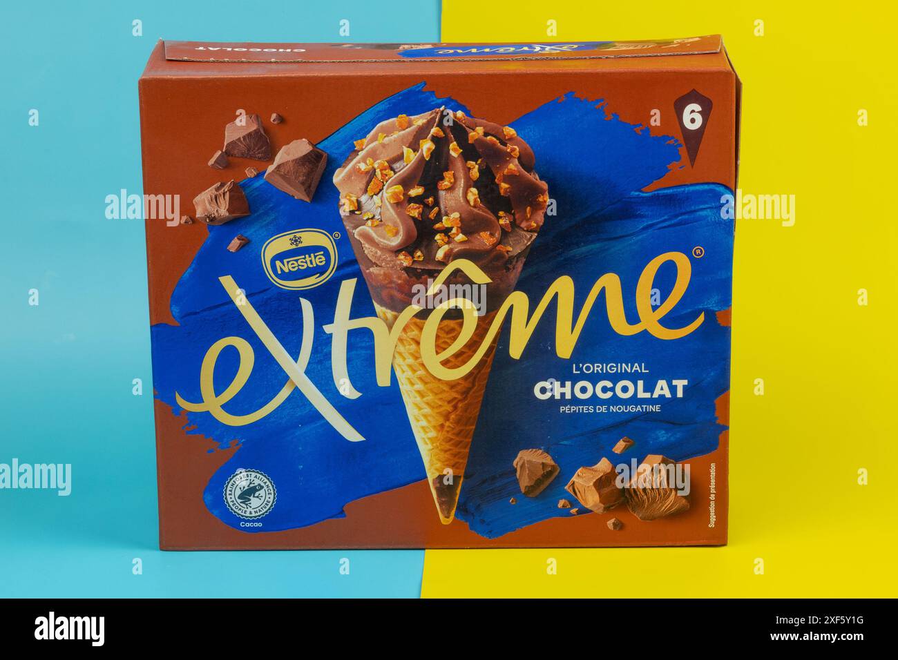 Scatola di coni per gelato Nestlé Extreme con gusto cioccolato isolati su sfondo giallo e blu Foto Stock