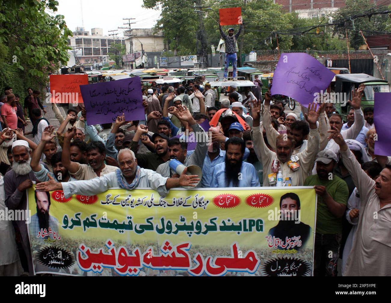 I membri della Mili Rickshaw Union stanno organizzando una manifestazione di protesta contro l'aumento dei prezzi dei prodotti petroliferi, presso il club stampa di Lahore lunedì 1 luglio 2024. Foto Stock