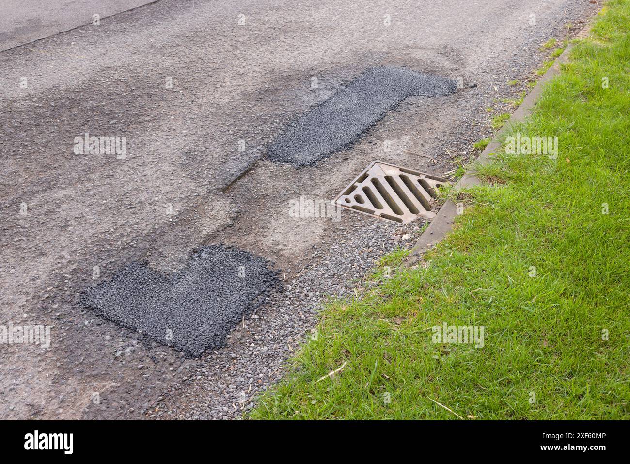 Riparazioni di toppe di buche su una strada di campagna in rovina. Manutenzione stradale nel Regno Unito. Buckinghamshire, Regno Unito Foto Stock