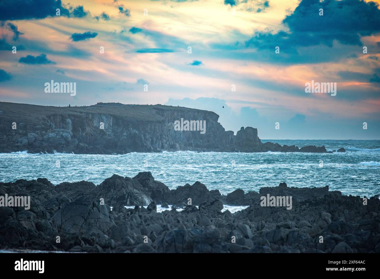 Splendida vista panoramica della costa rocciosa della penisola di Quiberon, Bretagna, Francia, al crepuscolo con un cielo spettacolare e dolci onde che colpiscono la riva. Foto Stock