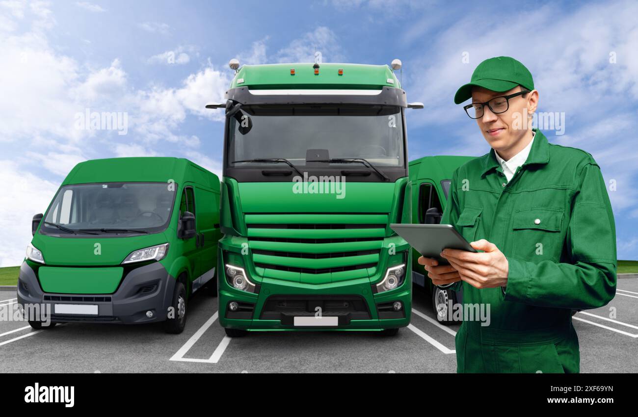 Manager con tablet digitale accanto a furgoni verdi e camion. Gestione della flotta. Foto Stock