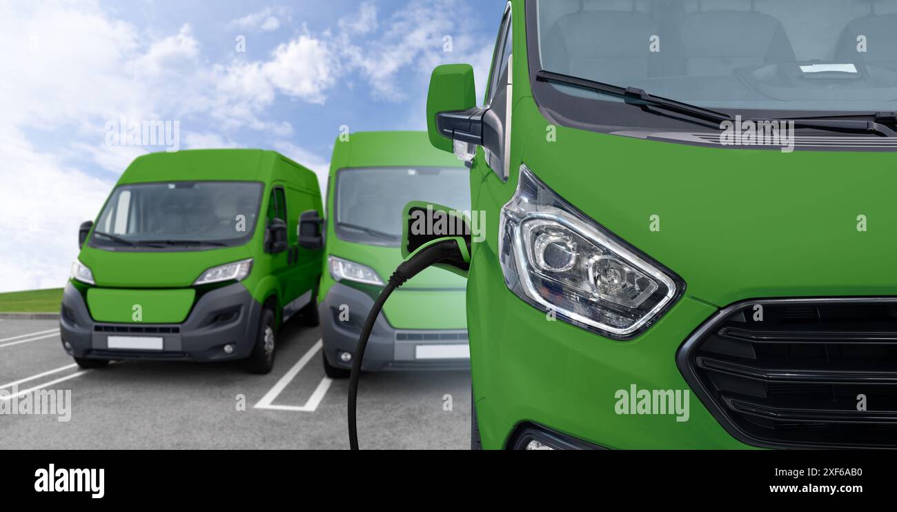 Furgone verde con cavo di ricarica collegato. Foto Stock