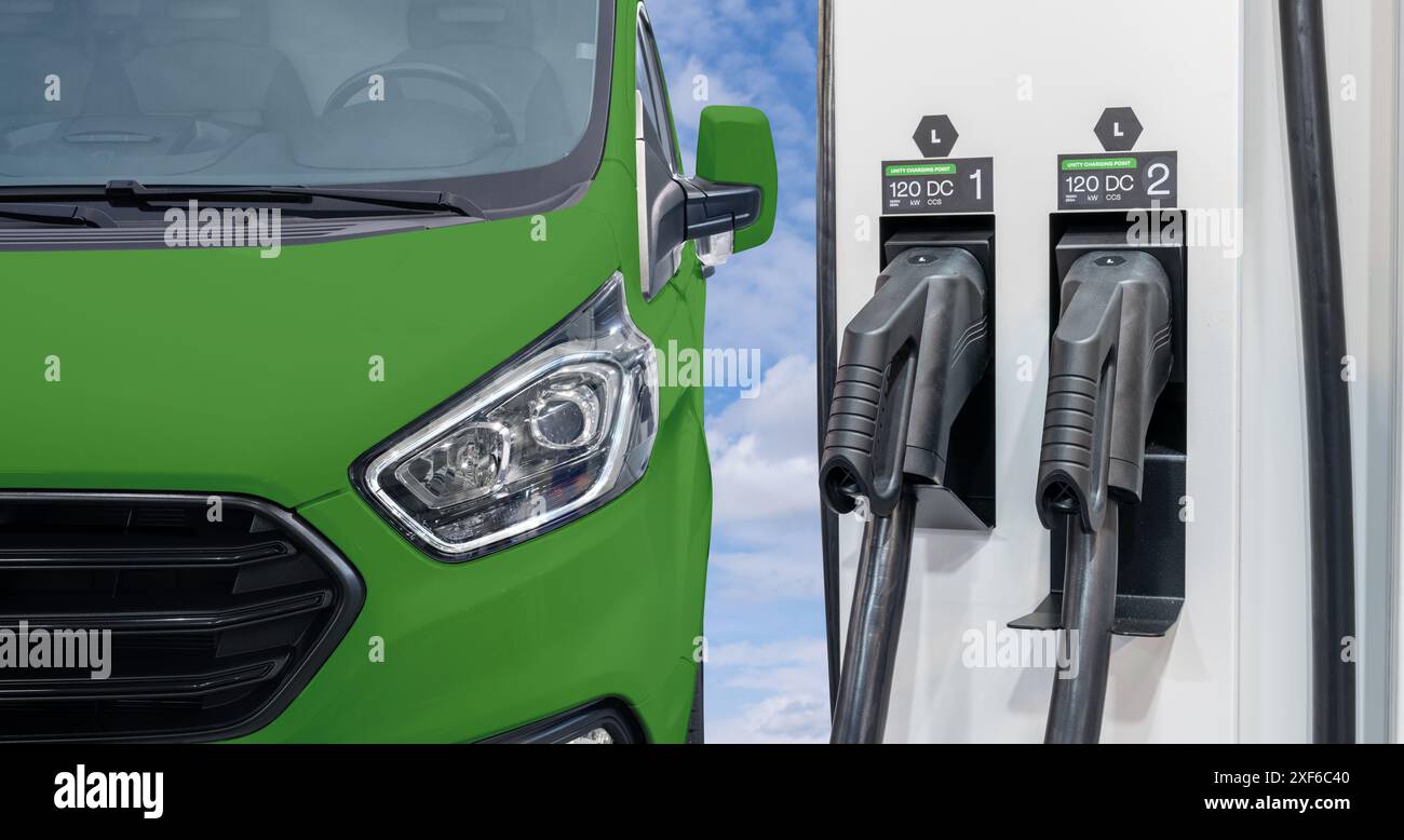 Furgoni elettrici verdi con stazione di ricarica per veicoli elettrici. Foto Stock