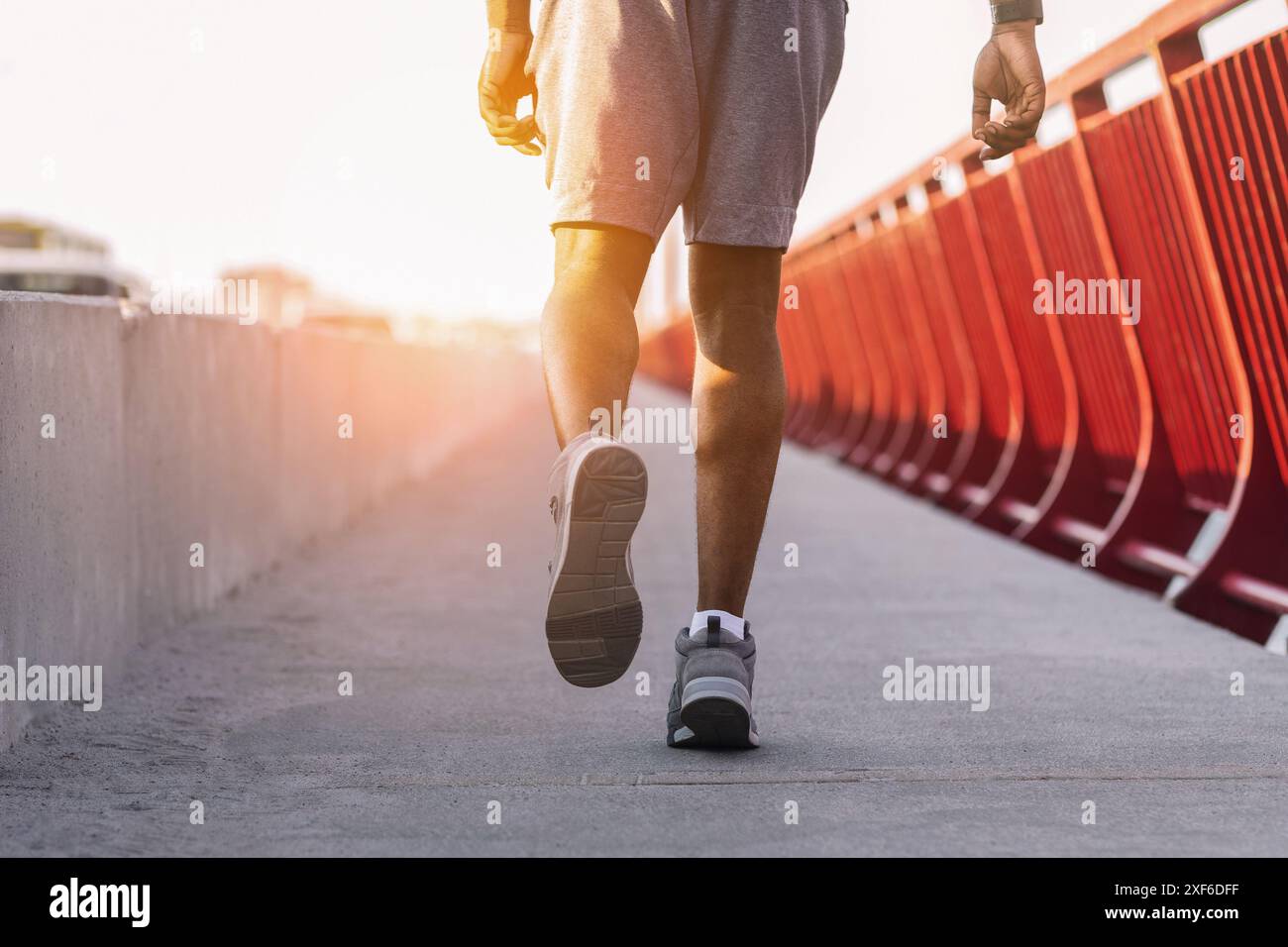 Immagine ritagliata di un uomo africano sportivo che corre sul ponte Foto Stock
