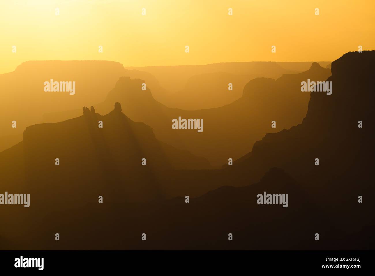 La luce gialla del sole sul Grand Canyon al tramonto crea strati di profondità e ombra attraverso le creste del South Rim Foto Stock