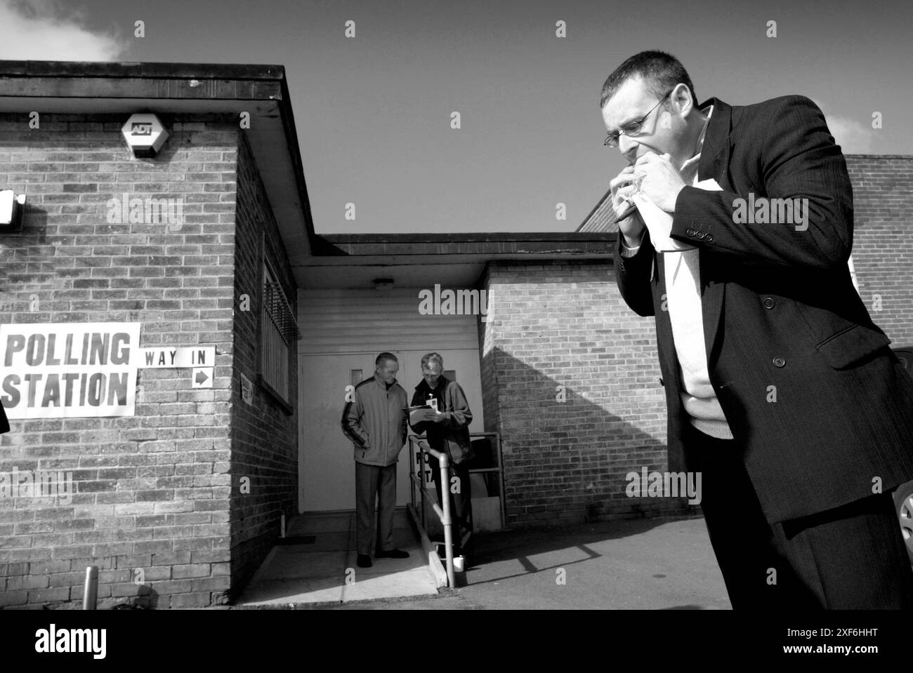 Un elettore prende un boccone da un panino durante la giornata elettorale a Mixenden, nel West Yorkshire, nel 2003. Foto Stock