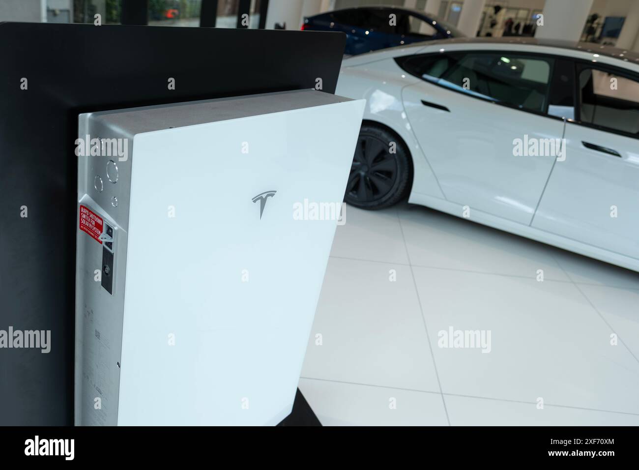 Dimostrazione della batteria powerwall modello tesla bianco nel salone di vendita ufficiale, popolare auto elettrica, azienda americana Elon Musk, produzione di veicoli elettrici Foto Stock