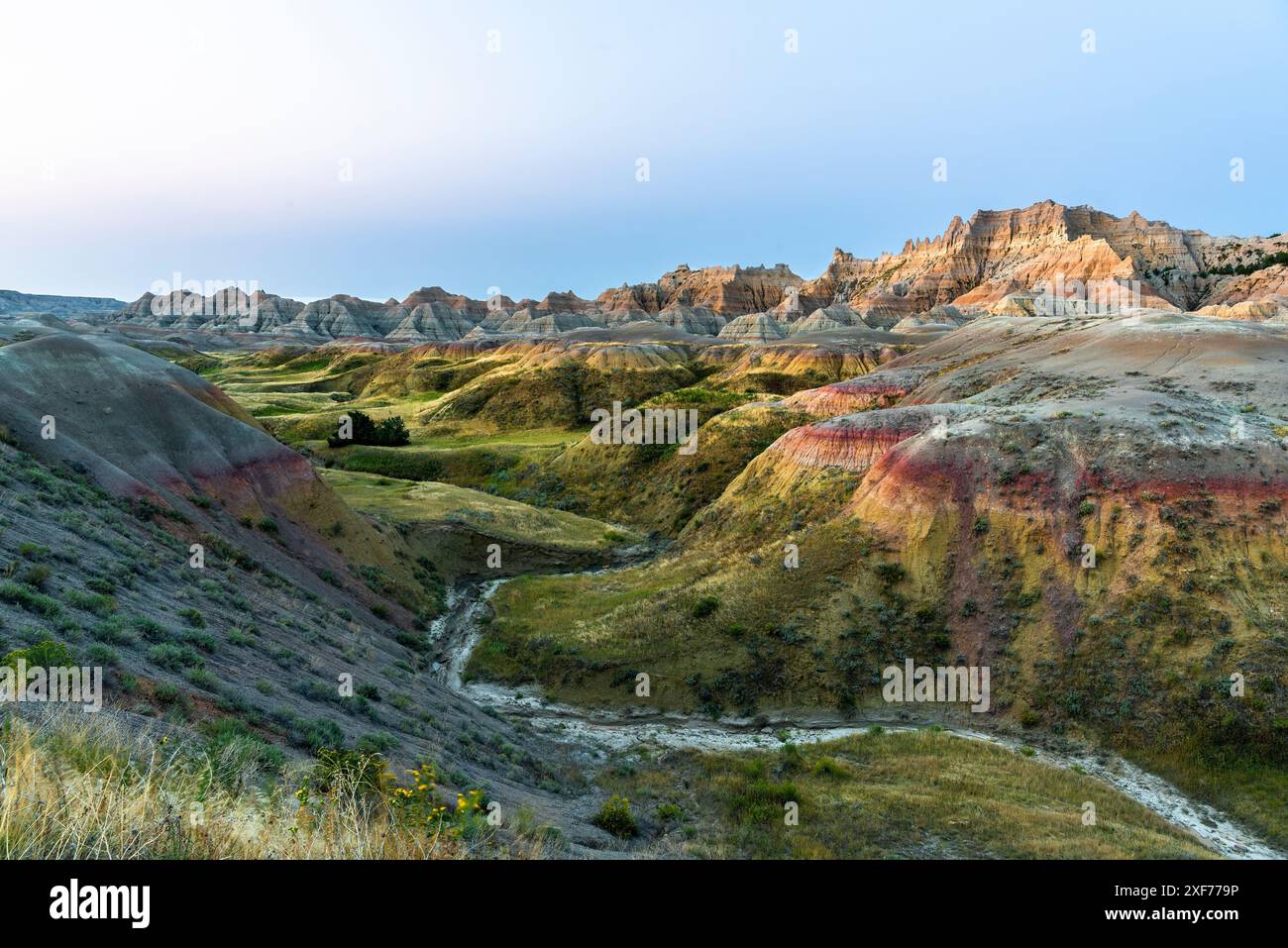 La valle verde con Dry creek è alimentata dalla corsa degli hoodoos che costeggiano il lato. Foto Stock