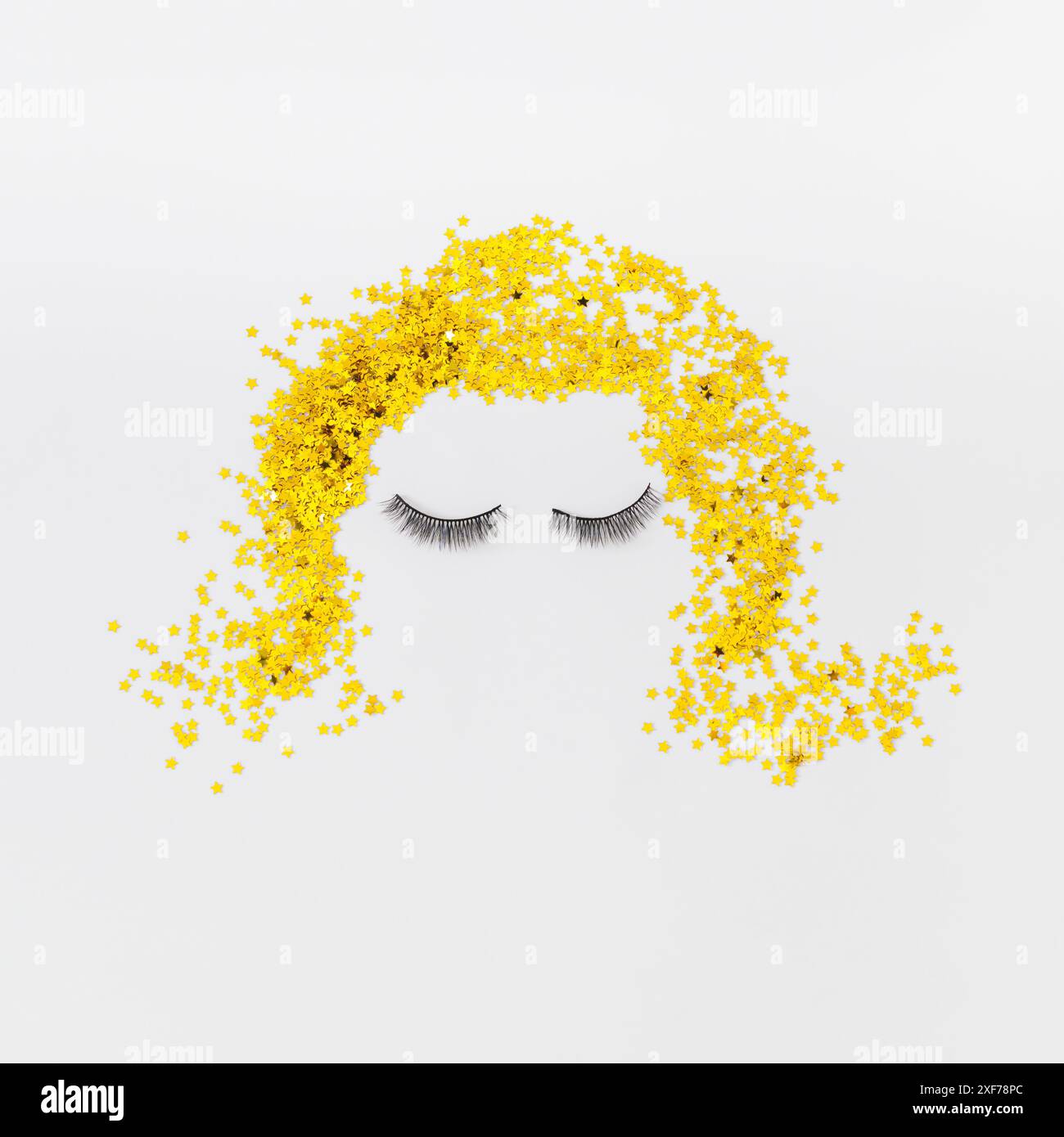 Il viso della bionda creativa è realizzato con ciglia finte e coriandoli di stelle glitter dorate su sfondo bianco. Stile di bellezza retrò. Foto Stock