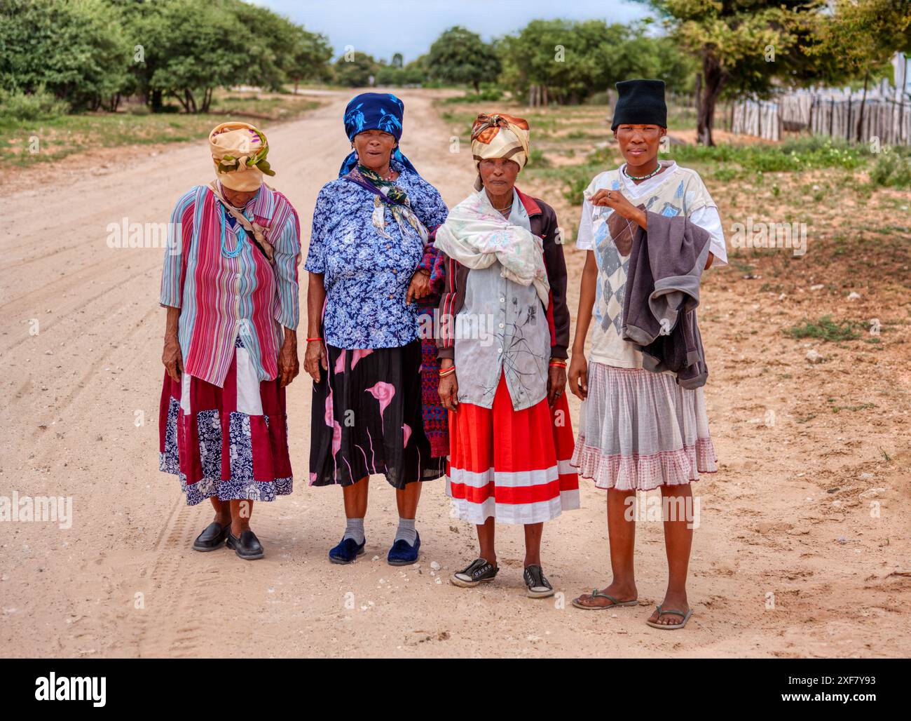 Basarwa quattro donne africane che camminano su strade sterrate, gente di San, villaggio nel Kalahari Foto Stock