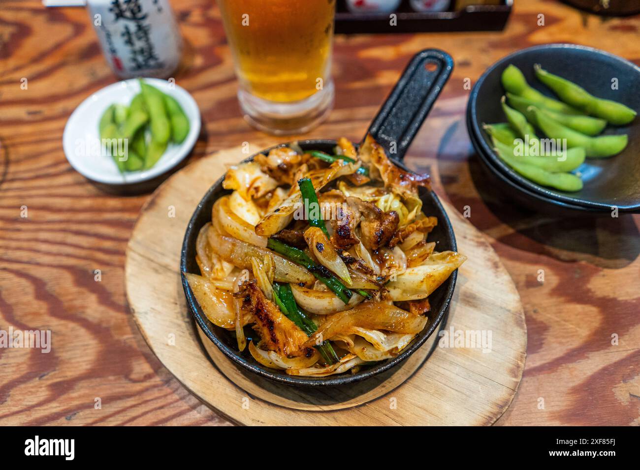 Osaka, Giappone, mescolare il manzo fritto e la cipolla all'izakaya Foto Stock