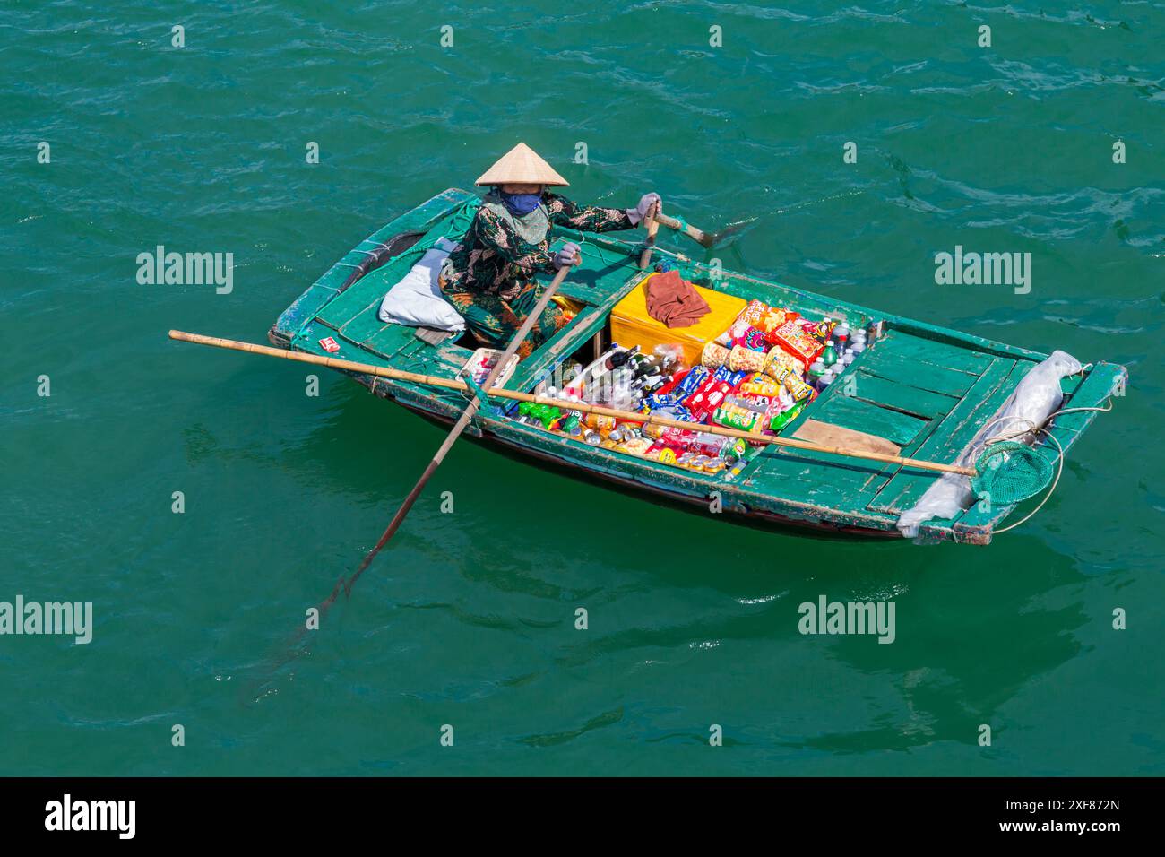 Venditrice locale vietnamita che vende articoli ai passeggeri sulle navi da crociera a ha Long Bay, Vietnam del Nord, Asia a giugno Foto Stock
