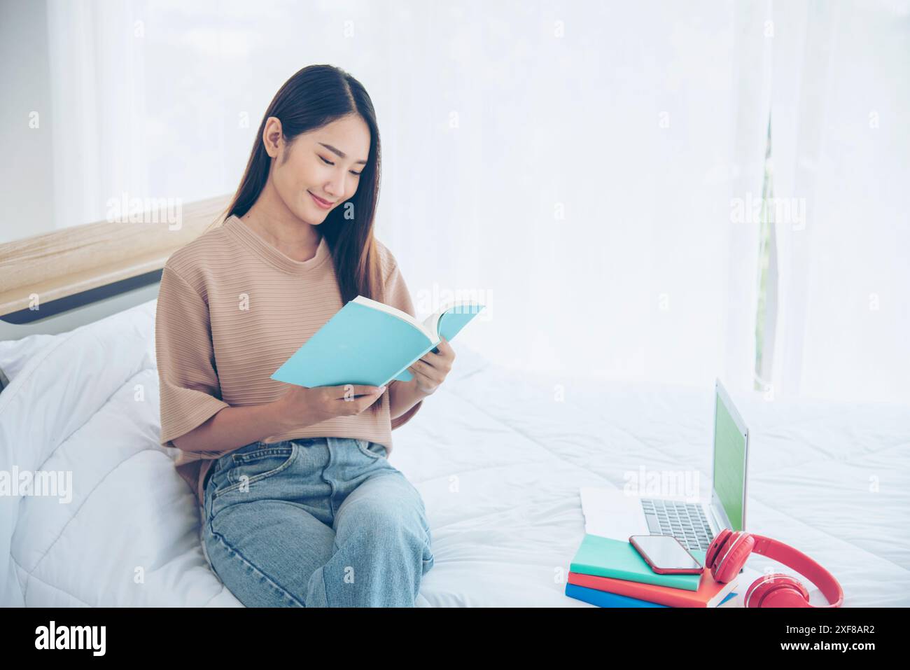 Rilassatevi con una donna che tiene un libro letto alla libreria della biblioteca universitaria. Giovane donna relax leggendo un libro aperto mente per il tempo libero. Bella donna intelligente intelligente Foto Stock