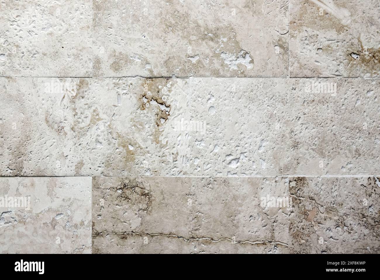 Parete grigia beige fatta di blocchi di pietra calcarea. Texture foto di sfondo, vista frontale ravvicinata Foto Stock