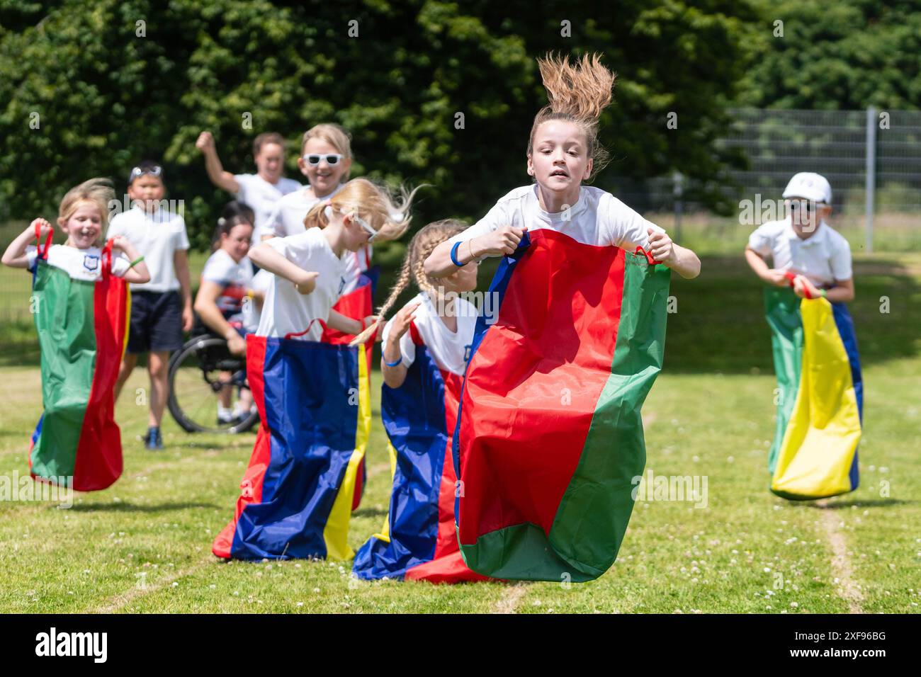 SOLO PER USO EDITORIALE anno 4 allievo, Flo partecipa alla gara di sack durante una "giornata positiva degli sport energetici", presso la St. Augustine's Catholic Primary School di Hythe, Kent, organizzata in collaborazione tra British gas e Heart radio. Data di pubblicazione: Martedì 2 luglio 2024. Foto Stock