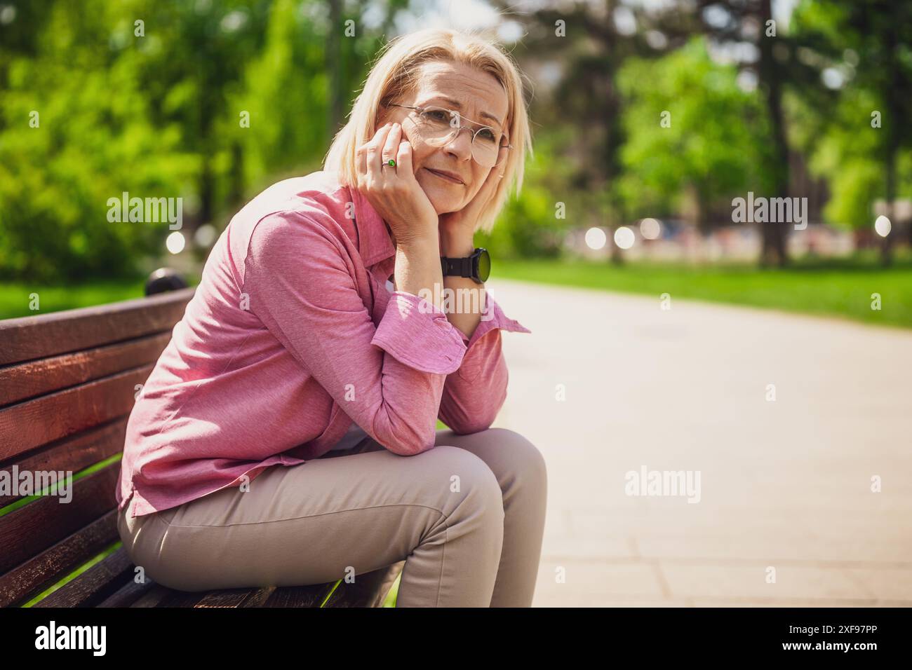 Ritratto di una donna matura nel parco. Lei è preoccupata e depressa. Foto Stock