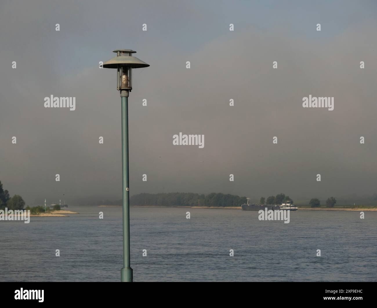 Un lampione sulla riva con sfondo nebbioso e orizzonte lontano, wesel, Renania settentrionale-Vestfalia, germania Foto Stock