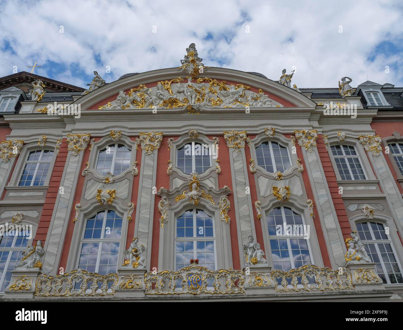 Dettaglio della facciata di un edificio barocco con ricche decorazioni, stucchi e accenti dorati sotto un cielo blu, treviri, germania Foto Stock