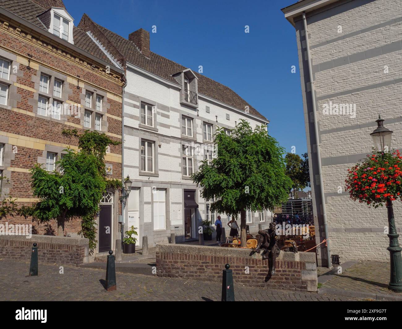 Diversi edifici storici e una strada con alberi e un'atmosfera estiva, maastricht. paesi bassi Foto Stock