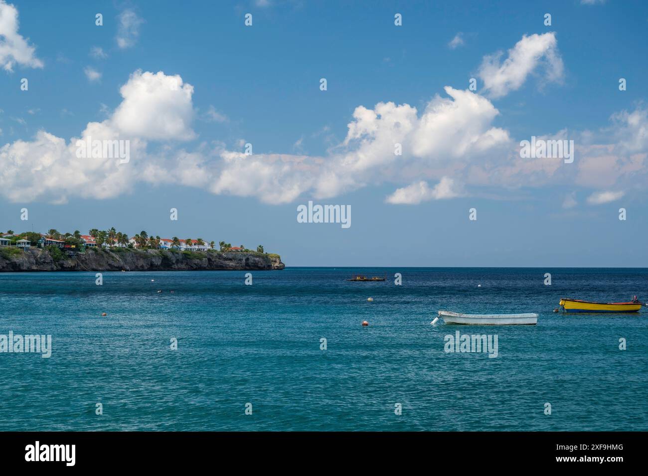 Piccole barche, ancorate nel mare, appena al largo della costa della spiaggia di Playa grandi, Curacao, Caraibi Foto Stock