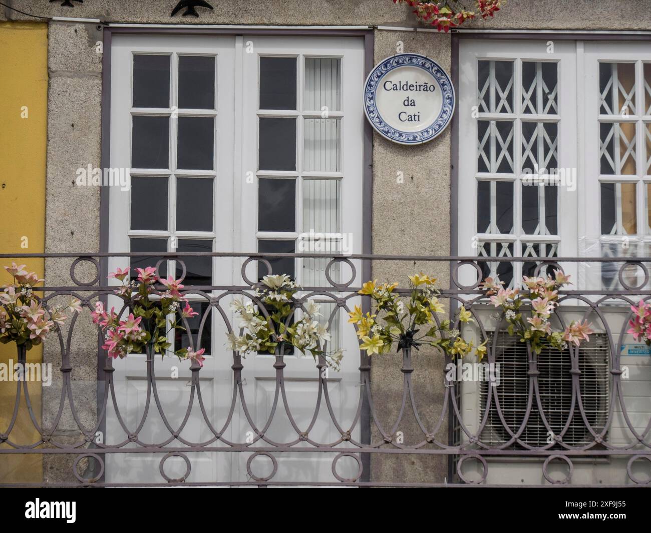 Ingresso a un edificio storico con ringhiere e cartelli decorati con fiori, porto, portogallo Foto Stock