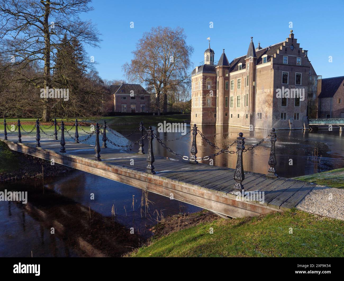 Un bellissimo castello con un fossato e un ponte, circondato da alberi in una giornata d'inverno limpida, ruurlo, gheldria, paesi bassi Foto Stock