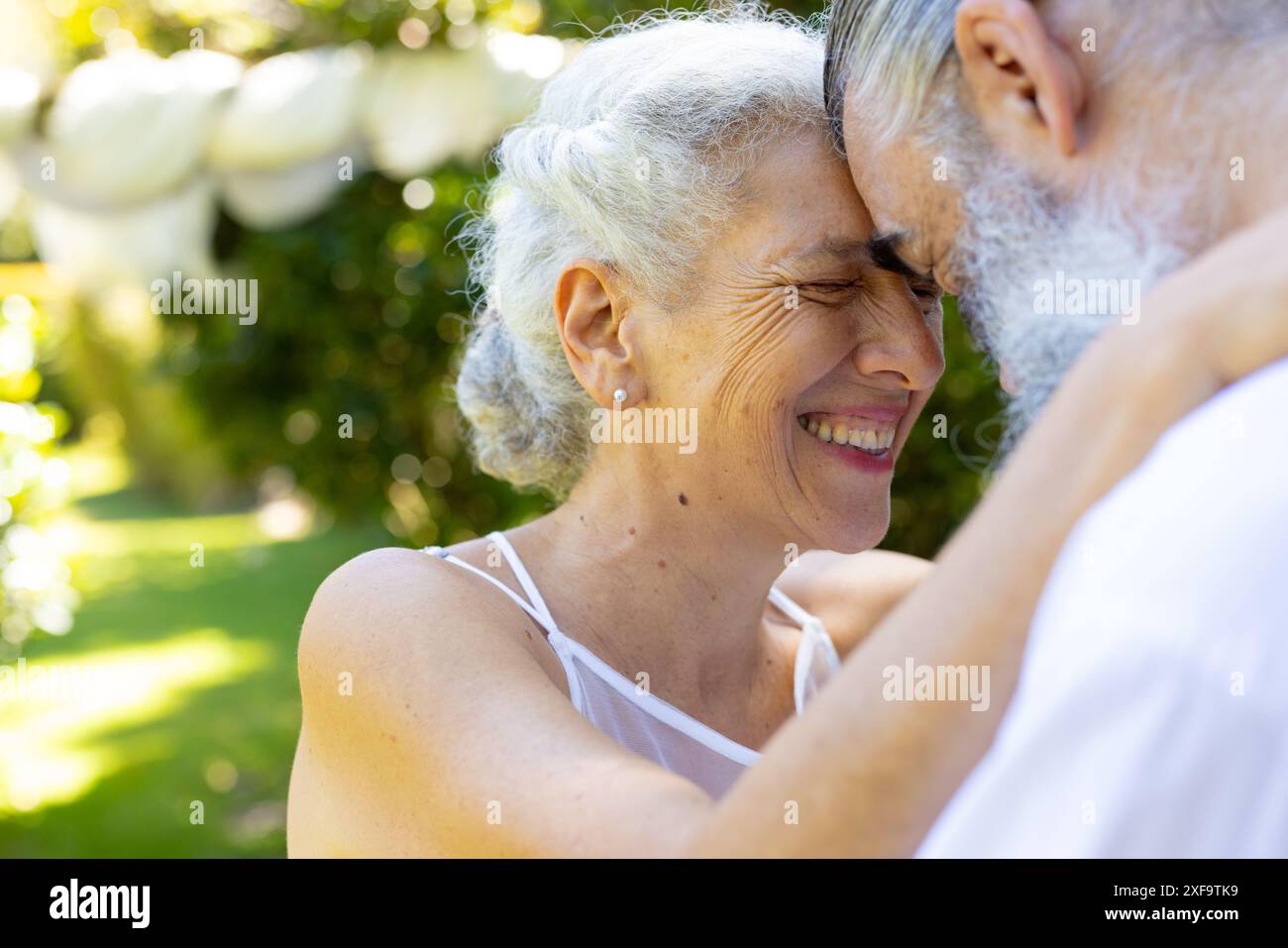 Abbracciare all'aperto, sorridere la sposa senior e lo sposo al matrimonio Foto Stock