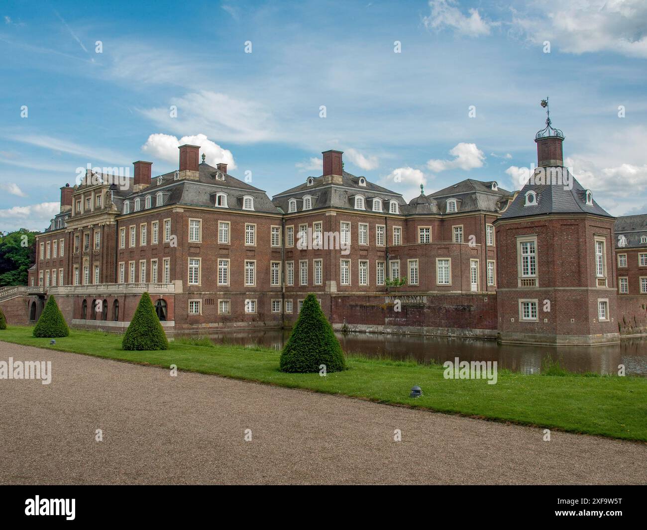 Uno storico castello in mattoni con diverse ali, circondato da spazi verdi e alberi sotto un cielo nuvoloso, nordkirchen, muensterland, germania Foto Stock