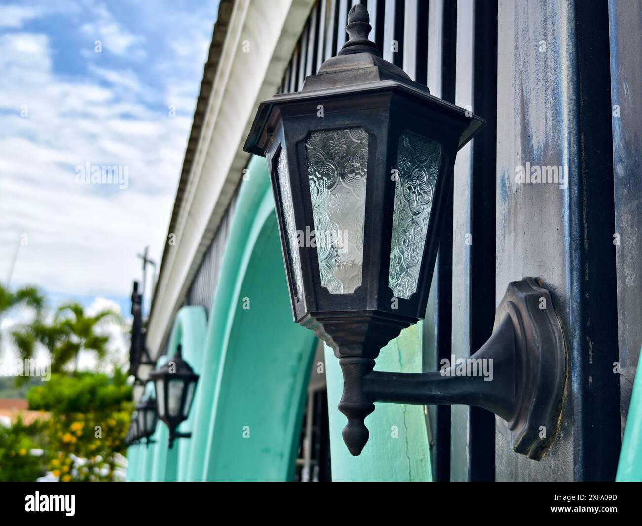 Edificio bianco con finestre ad arco, finiture blu, alto sotto il cielo limpido Foto Stock
