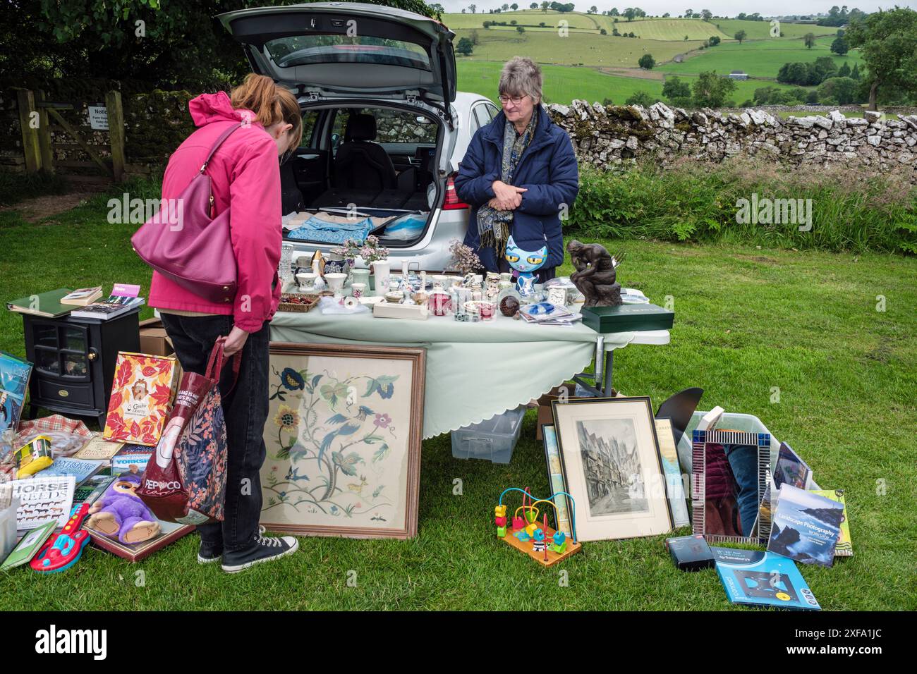 Stallholder in una vendita di stivali rurali nel villaggio di Alstonefield, Staffordshire Moorlands, Peak District, Inghilterra Foto Stock Stallholder in una vendita di stivali rurali nel villaggio di Alstonefield, Staffordshire Moorlands, Peak District, Inghilterra Foto Stock