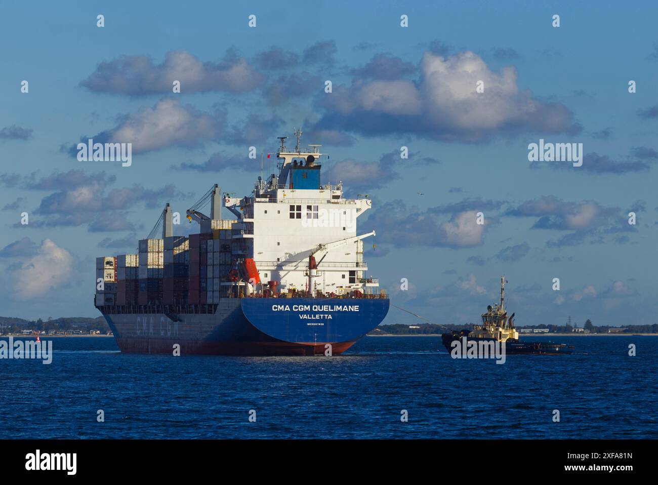 Una grande nave portacontainer è assistita da un rimorchiatore nel porto di Sydney, nuovo Galles del Sud, Australia. Foto Stock