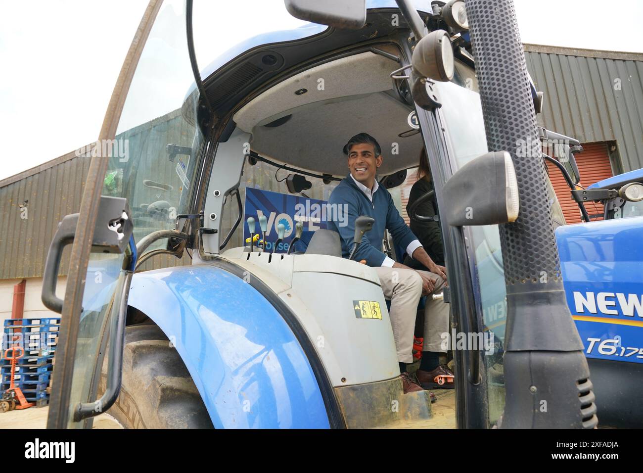 Il primo ministro Rishi Sunak seduto su un trattore durante una visita alla Wykham Park Farm a Banbury, nell'Oxfordshire, mentre era sulle tracce della campagna elettorale generale. Data foto: Martedì 2 luglio 2024. Foto Stock