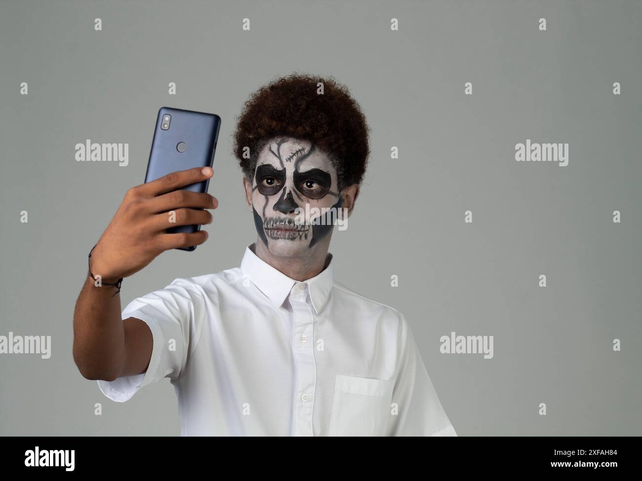 catrin teen con capelli afro che si fa un selfie Santa muerte concept Foto Stock
