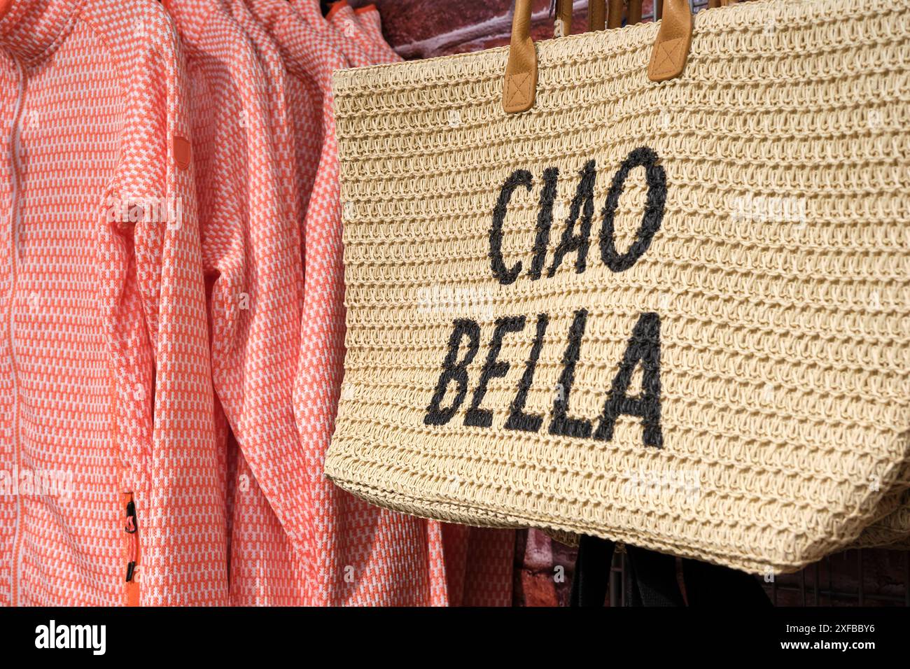 Borsa intrecciata con manico in pelle stampato con testo italiano Ciao bella in una boutique. Ciao bella significa "Ciao bello" in lingua inglese. Foto Stock
