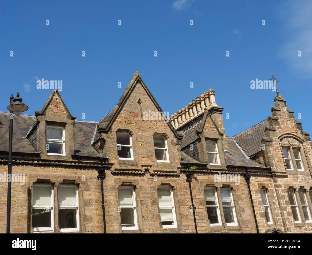 Un edificio storico con diverse finestre e torri caratteristiche contro un cielo blu, Inverness, Scozia, Regno Unito Foto Stock