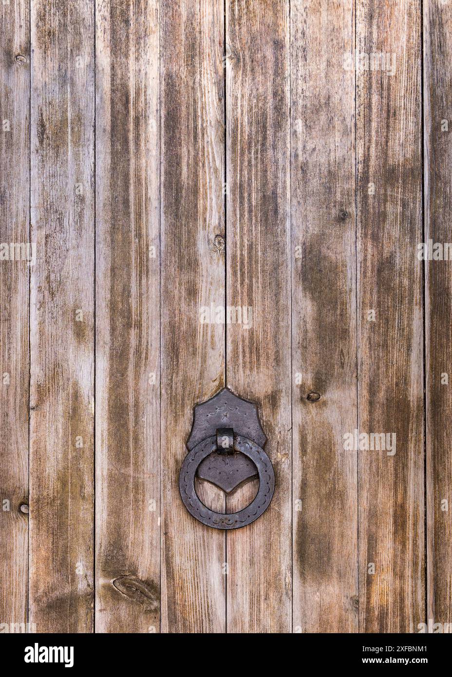 Parte di una grande porta in legno con maniglia in ferro e anello. Spagna Foto Stock