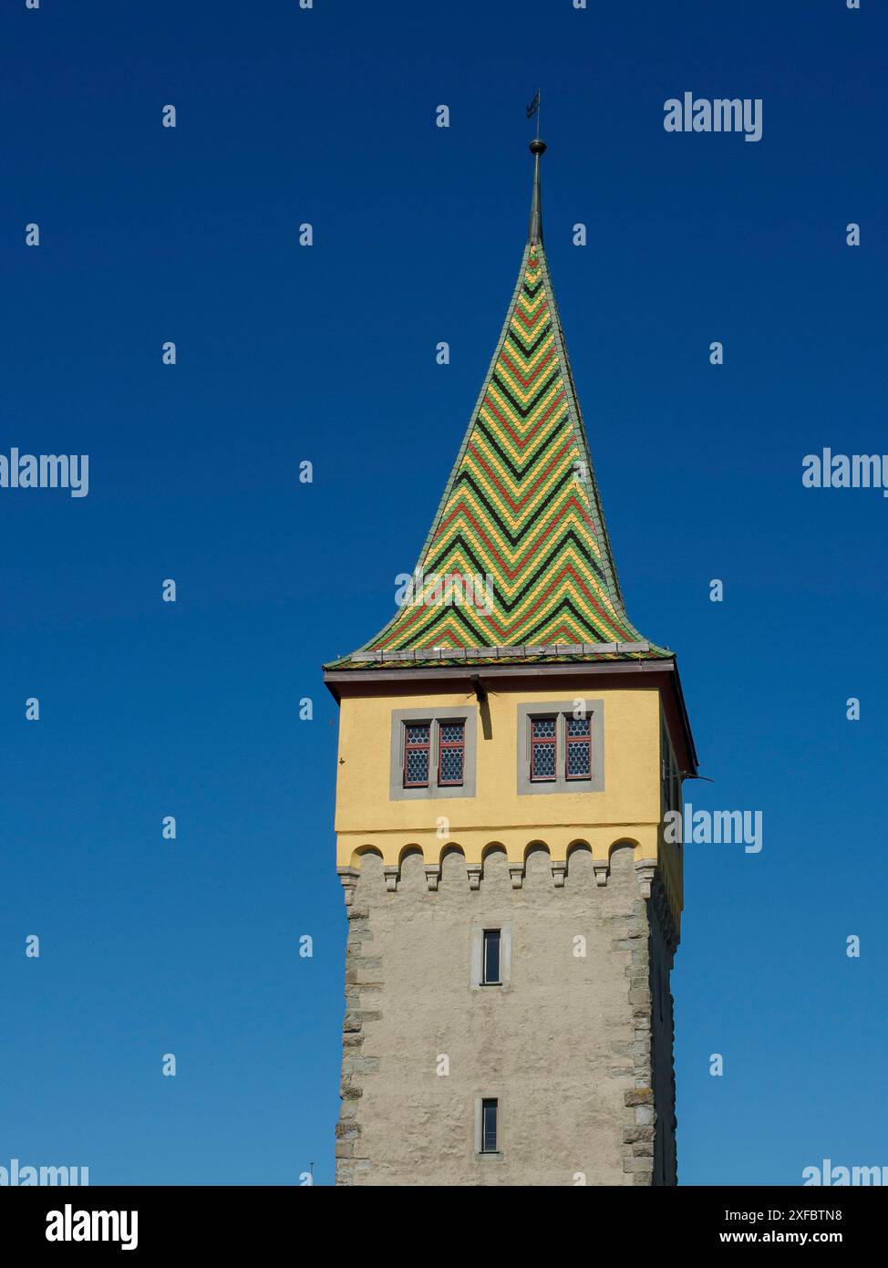 Torre gialla con tetto verde-giallo e cielo blu, lindau, baviera, germania Foto Stock