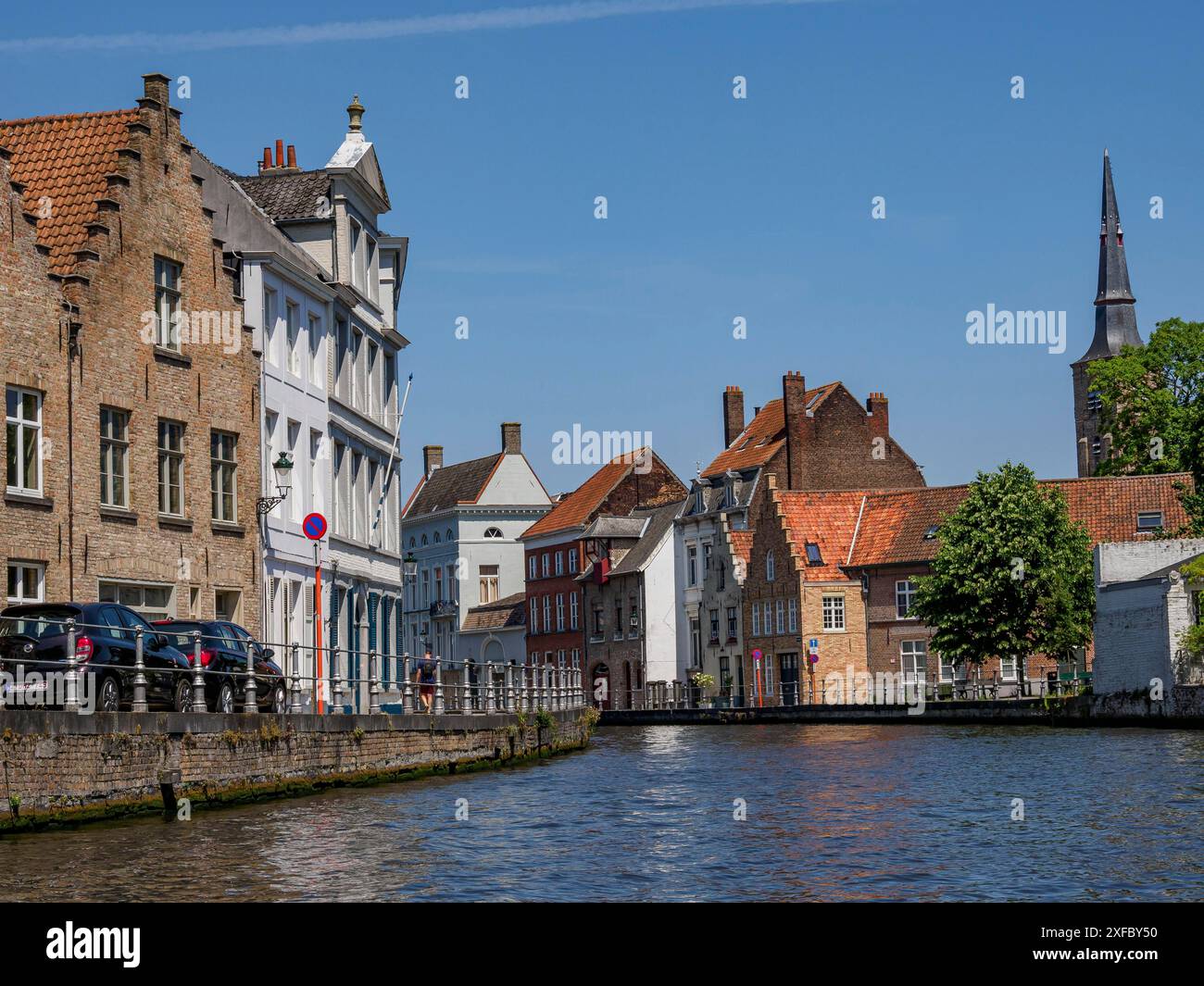 Tranquillo canale con storiche case in mattoni e riflessi nelle acque cristalline, Bruges, Fiandre, Belgio Foto Stock